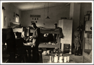 1942-43 inside barracks, porcelain stove visible on the right, barracks bunks and general layout